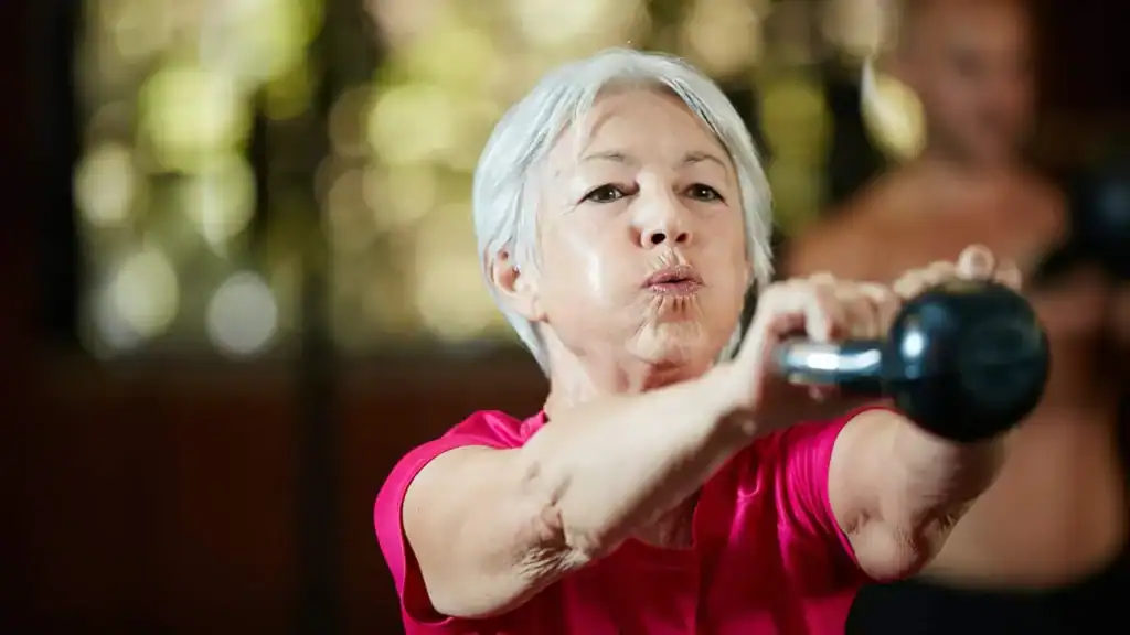 Toning Arms After 60: Empowering Womens Fitness Through Effective Weight Training 1 Older woman doing weight training Essex to help her strength and longevity